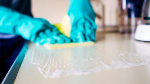 Technician wearing PPE while cleaning a carpet